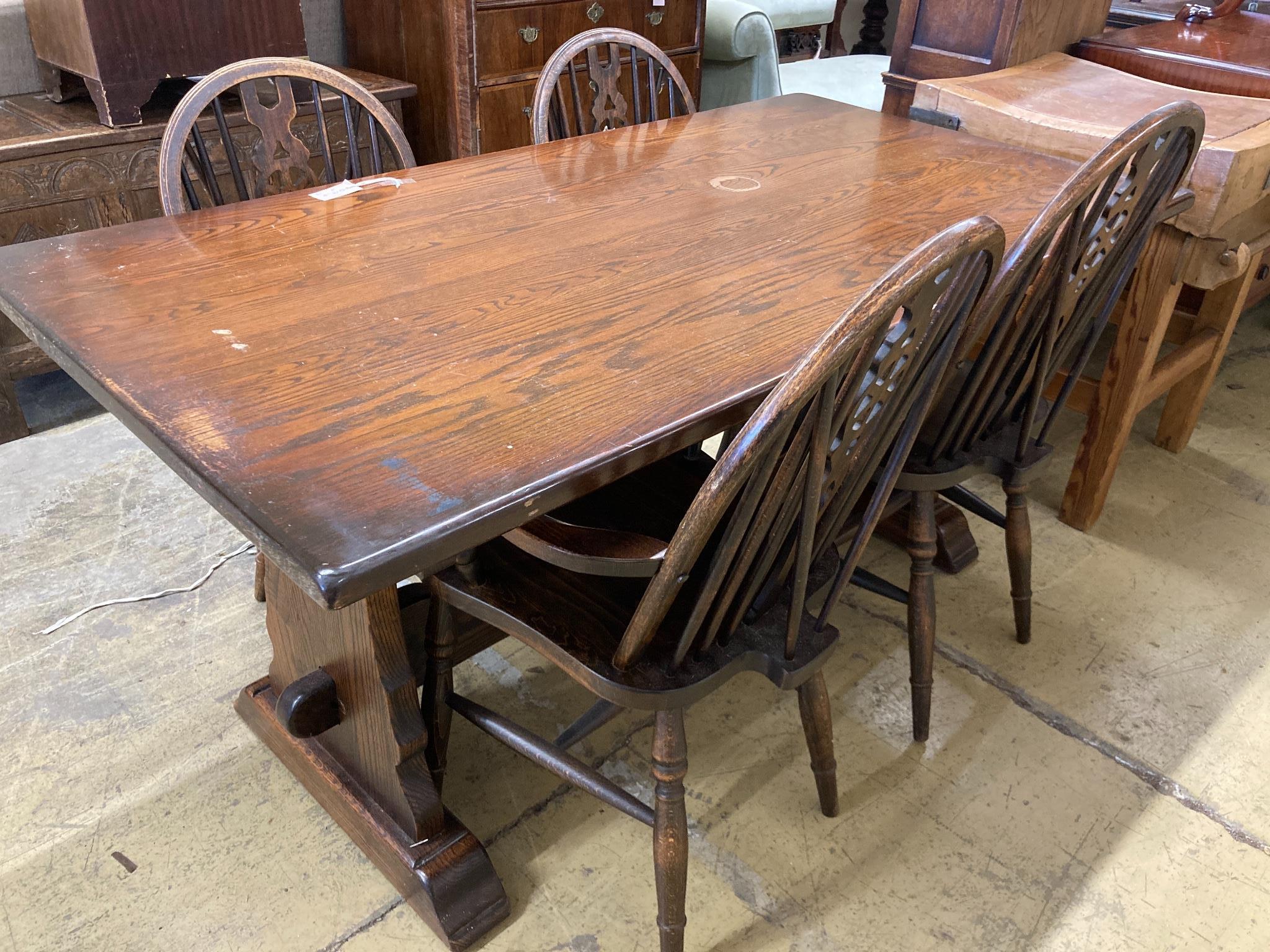 A 17th century style oak 'refectory' table on shaped trestle end supports, length 160cm, depth 83cm, height 75cm and four wheelback Windsor chairs